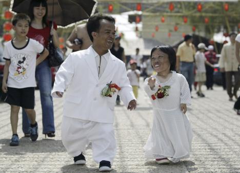 Midget Li Tangyong (2nd L) 33, and his fiancee Chen Guilan (R) 28 attend a mass wedding ceremony rehearsal on a farm in Foshan, south China's Guangdong province October 5, 2007.Li, who is 1.1metres tall (3.6 feet), and Chen, who is 0.7 metres-tall (2.3 feet), participated in the rehearsal with 21 other couples.They will get married later this year, local media reported.Picture taken October 5, 2007.REUTERS/Joe Tan (CHINA) CHINA OUT *** Local Caption ***